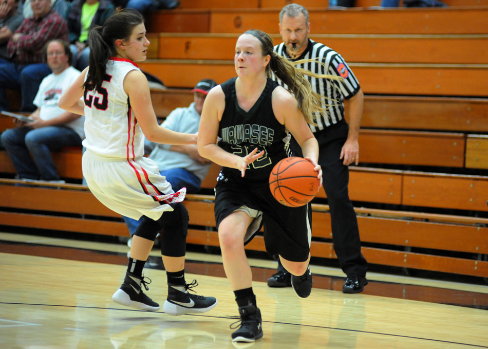 Hannah Haines of Wawasee works toward the basket past NorthWood's Gabi Glass.