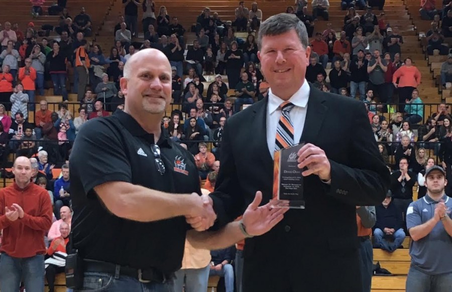 Warsaw boys basketball coach Doug Ogle (at right) was honored Saturday night for his 200th coaching win earlier this season. Ogle is congratulated by WCHS Athletic Director Dave Anson.