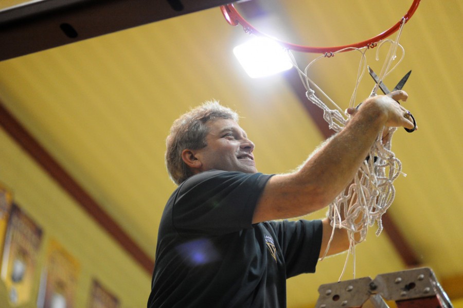 Wawasee girls basketball coach Kem Zolman cuts down the net in 2011 after his team won a sectional title at Columbia City. Zolman retired on Wednesday after 18 years as the Warriors' coach (File photos by Mike Deak)
