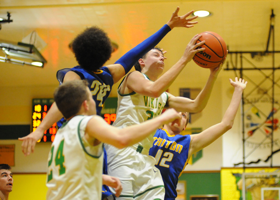 Neil Clampitt pulls down a rebound in between Zac Pitney (24) and Masen Yeo.