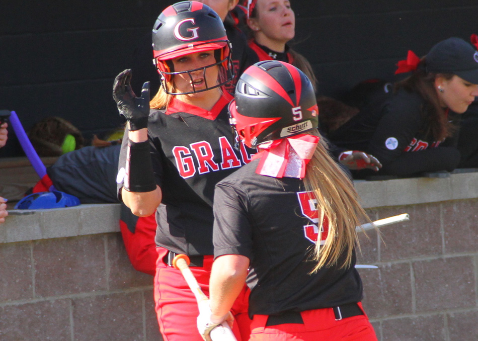 Grace softball's Ashley Kleinbub celebrates a run in game one with Abby Mozingo Monday afternoon. (Photo provided by the Grace College Sports Information Department)
