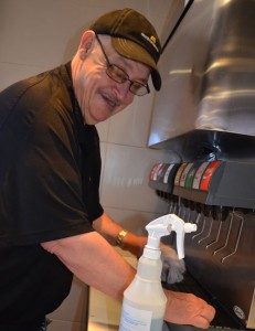 James Sweet grins as he reassembles the pop machine he has just cleaned.