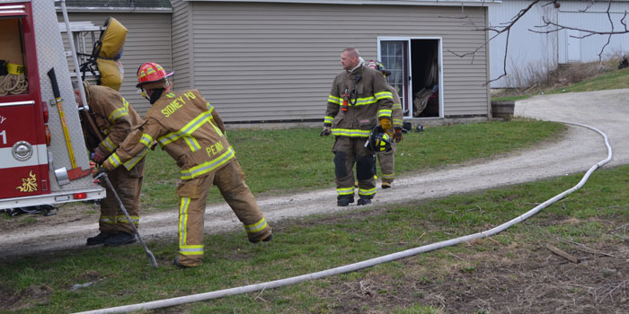 Firefighters pack up after successfully putting out a small fire in a house south of Sidney. (Photo by Amanda McFarland(