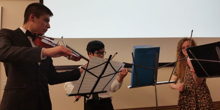 A string trio serenaded the crowd prior to the start of the WCS board of trustees meeting.