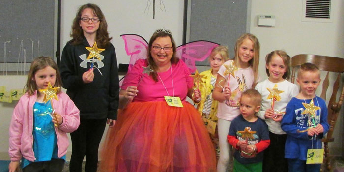 The Book Fairy, Julie Frew, reads Fairy Tales to story time children on Wednesday, April 6. The children created fairy wands during craft time. Here they pose for a picture with the Book Fairy and their finished wands. Listed from the left are Zoey Rushlow, Apryl Wray, Julia Frew, Ava Makinson, Myla Miller, Alex Miller, Shelby Miller, and Charlie Miller.