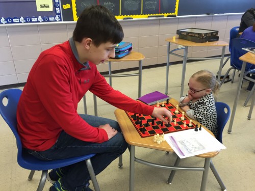 Brandon Kitch makes a move on the chess board as he plays Ashley Kaufman