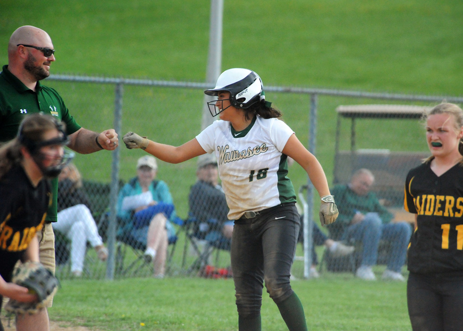 Wawasee's Allissa Flores fist bumps head coach Jared Knipper after tripling in two runs.