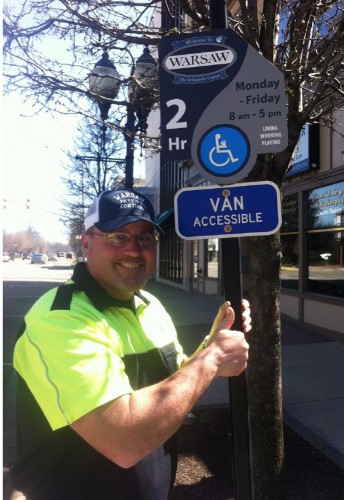 City Parking Control Officer Dana Hewitt shows off the new handicapped accessible signs installed downtown Warsaw.