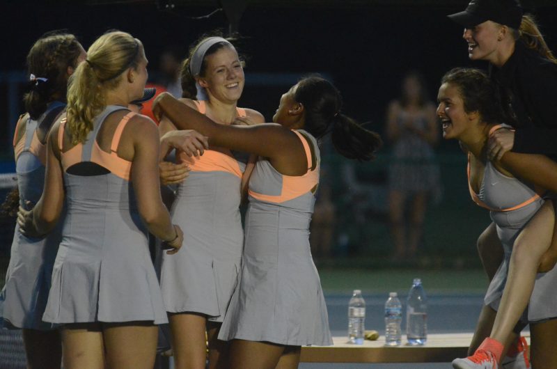 Colette Smith is mobbed by her teammates after her win gave Warsaw a tennis regional championship Wednesday night.