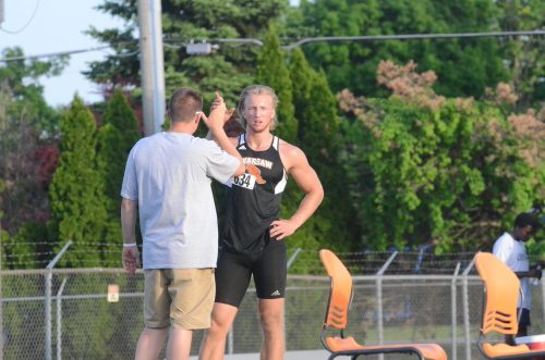 Tommy Hickerson receives congratulations from his coach after placing second i the long jump.