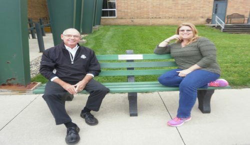 Dennis Wagoner and Erin Smith sit on a bench donated by The Depot. The bench is outside the North Webster Community Center