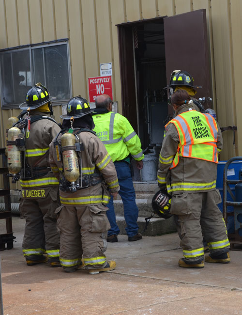 Firefighters wait outside the building.