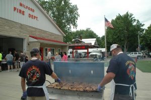 Gavin Foster, left and Scott Mast, of the Milford Fire Department, helped grill 500 ribeye steaks at Milford Fest.