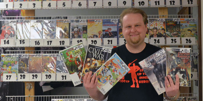 Nick Kelley, owner of Chimp's Comix, displays some of the titles to be given away during Free Comic Book Day on Saturday, May 7