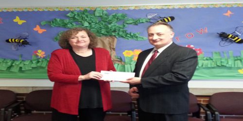 Cindy Cates, executive director of Kosciusko Literacy Services, accepts a donation from the Esther Pfliederer Charitable Trust from Trevor Ross, vice president and trust officer of First Source Bank