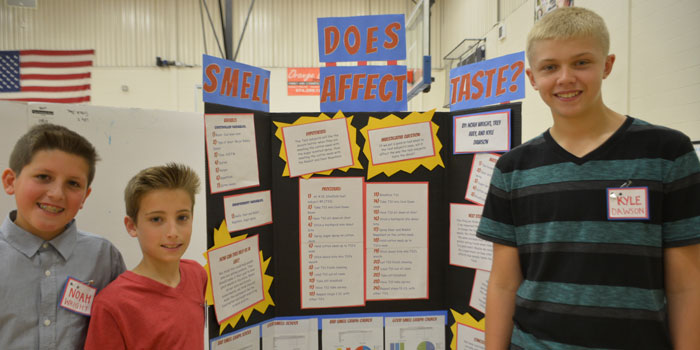 From the left, Noah Wright, Trey Avey and Kyle Dawson pose in front of their project titled, "How Does Smell Affect Taste?"