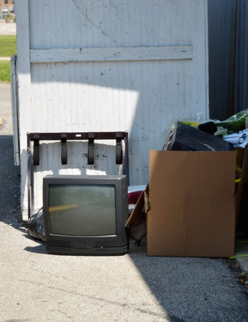 An abandoned CRT television sitting outside Our Father's House donation box.