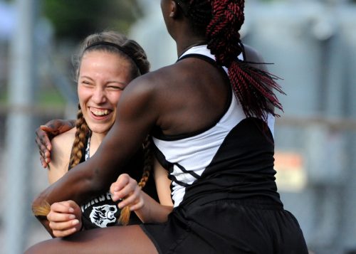 Abbi Curtis of Warsaw is mobbed by teammate Shunterra Davis after landing a PR in long jump.