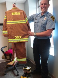 Warsaw Firefighter Matt Kinsey shows the child size turnout gear to be worn by students chosen as Firefighter For the Day.