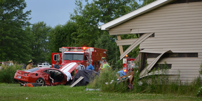 Crews work to free the passenger and driver of a vehicle that collided with a house. (Photos by Amanda McFarland)