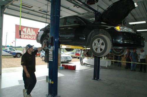 Price Auto Repair technician, Todd Monroe, services the second car in the new building. The first car serviced was founder Stan Price's. (Photo by David Hazledine)