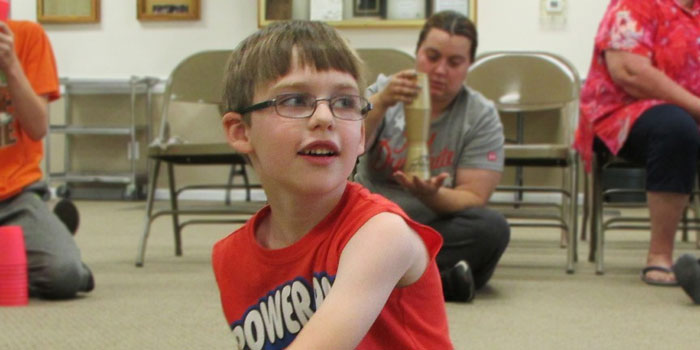 Noah VanderReyden watches and imitates Mr. Jim as he shows the crowd tricks of Sport Cup Stacking.