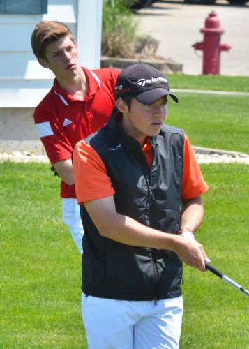 Warsaw's Tim Rata (front) checks out his drive at the NLC championship with Plymouth's Hudson Yoder watching from behind. (Photo by Nick Goralczyk)