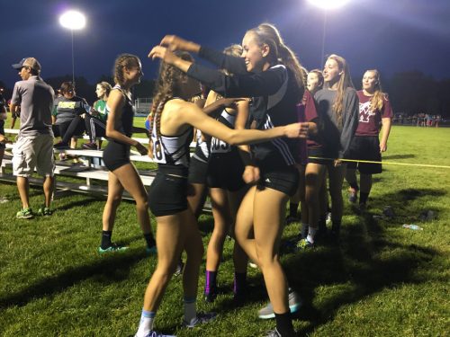 Audrey Rich is smothered by teammate Dayton Groninger after Rich brought home a regional title in the 4x400 relay.