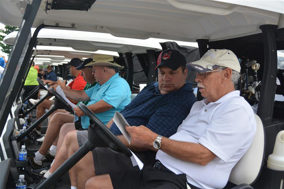 Marty Becker, near in white, reviews the golf program ahead of the ninth-annual Warsaw Optimist Golf Outing. (Photo provided)