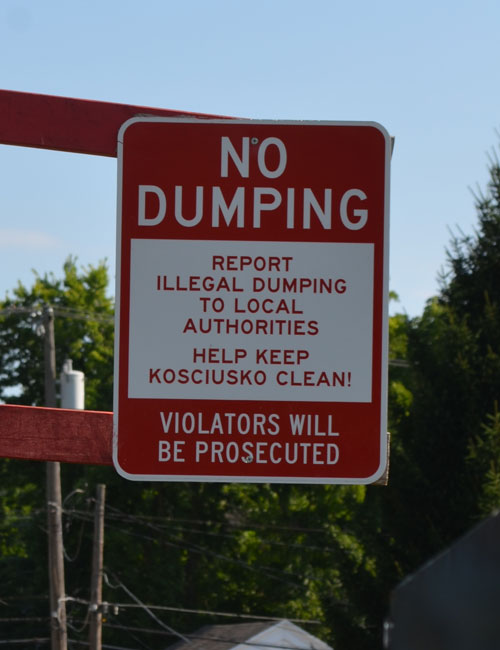 A sign near the recycling bins warns users against dumping.