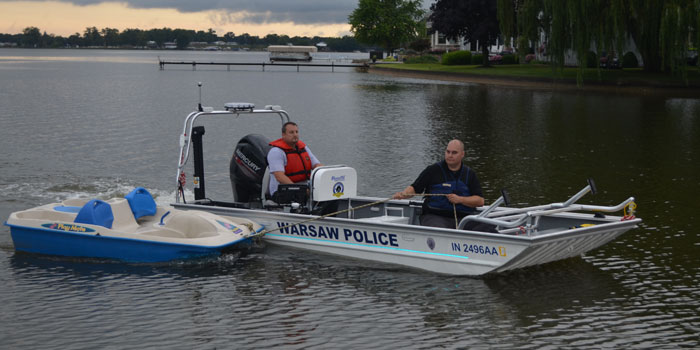 Officers tow the missing paddle boat back to shore. (Photos by Amanda McFarland)
