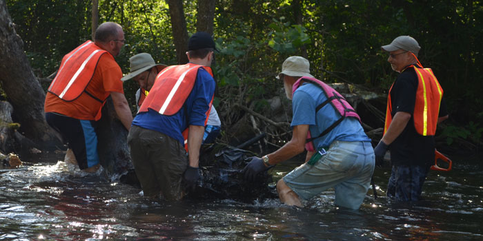 Volunteers work to remove a large section of a log that had fallen in the water. (Photos by Amanda McFarland)