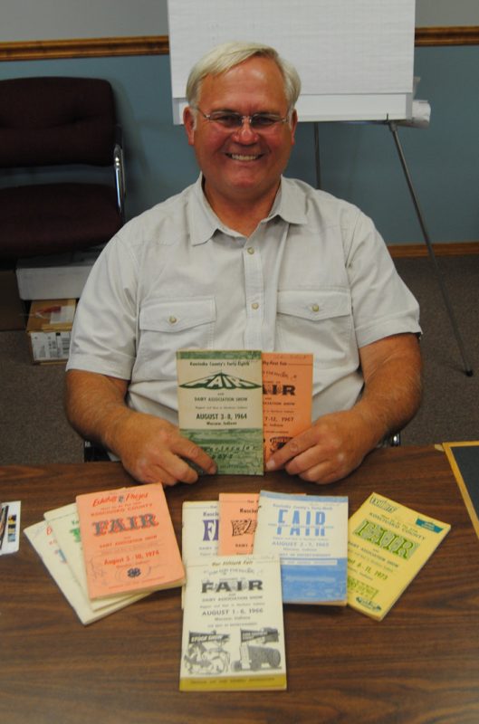 The Kosciusko County Community Fair is celebrating its 100th anniversary. Pictured is Steve Trump, a former, seven-time fair board president, looking at older fair books. (Photo by Phoebe Muthart)