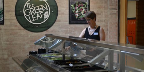 WCS Food Services Director Marci Franks shows off the new Green Leaf salad bar at Lakeview Middle School.