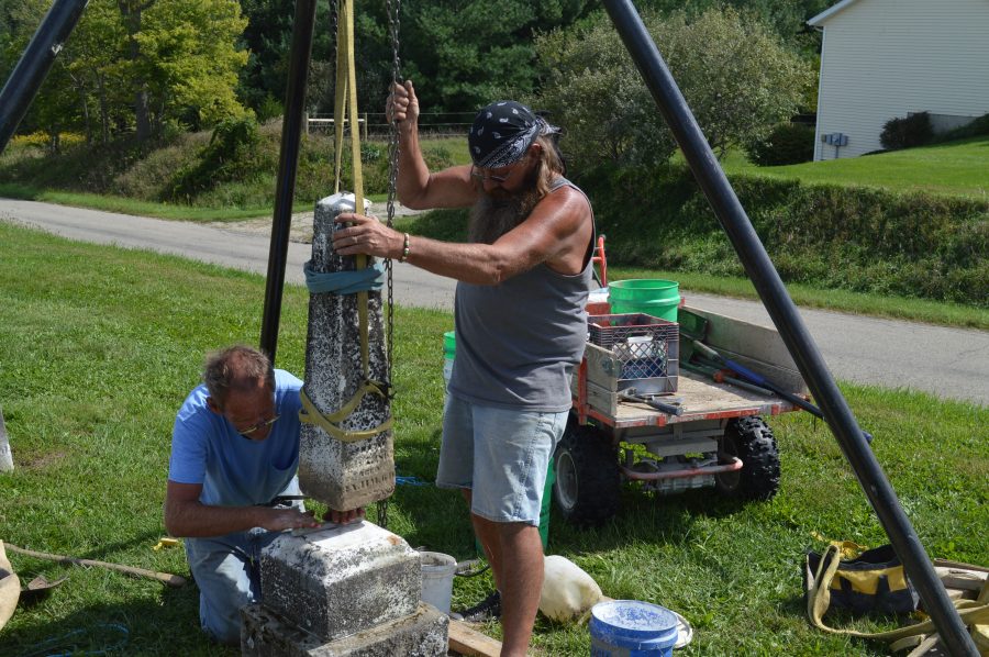 John “Walt” Walters, right, and his brother, Larry Walters, are working on stabilizing a grave marker at the Pleasant View Cemetery in Prairie Township.