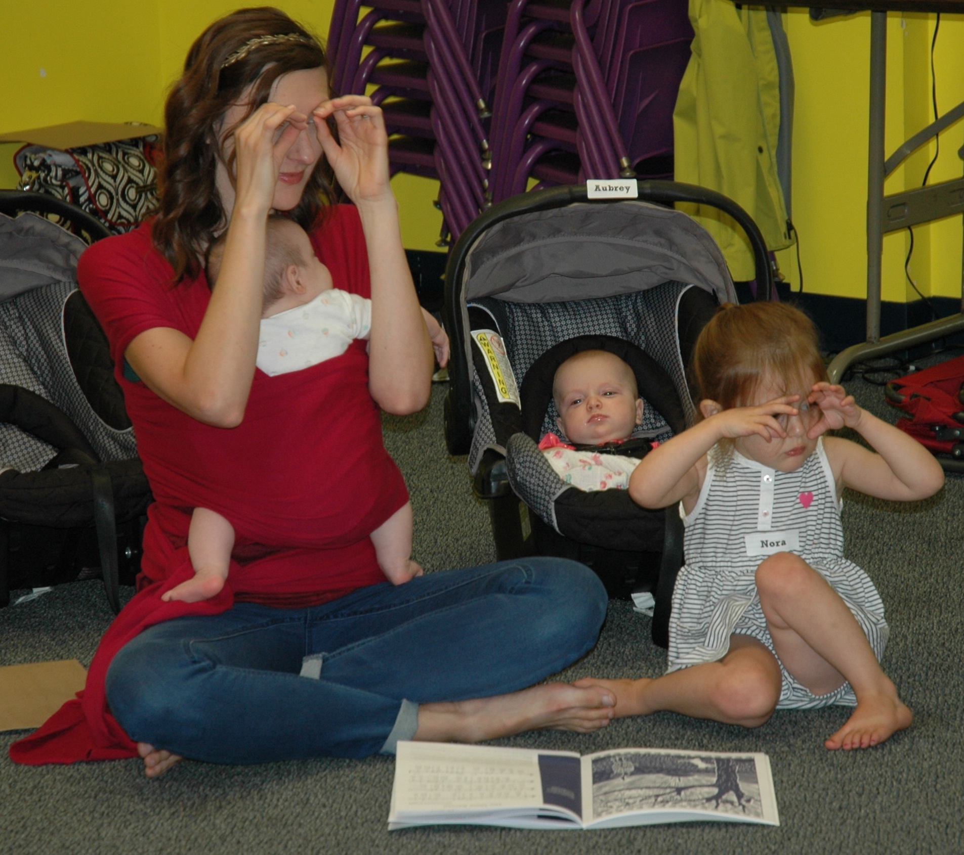 Lake City Music Together students learn not only songs but animals and animal noises as well in this lesson. Pictured from left are Angela, Leah, on Angela’s chest, Aubrey and Nora Bean making owl eyes while singing about the owl in the tree. (Photo by Nicholette Hodgson)