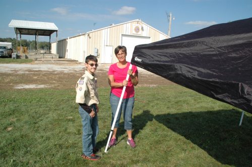 Mary Brower, right, helped her son Evan, left, a North Webster boy scout, take down their popcorn tent after the fall festival.