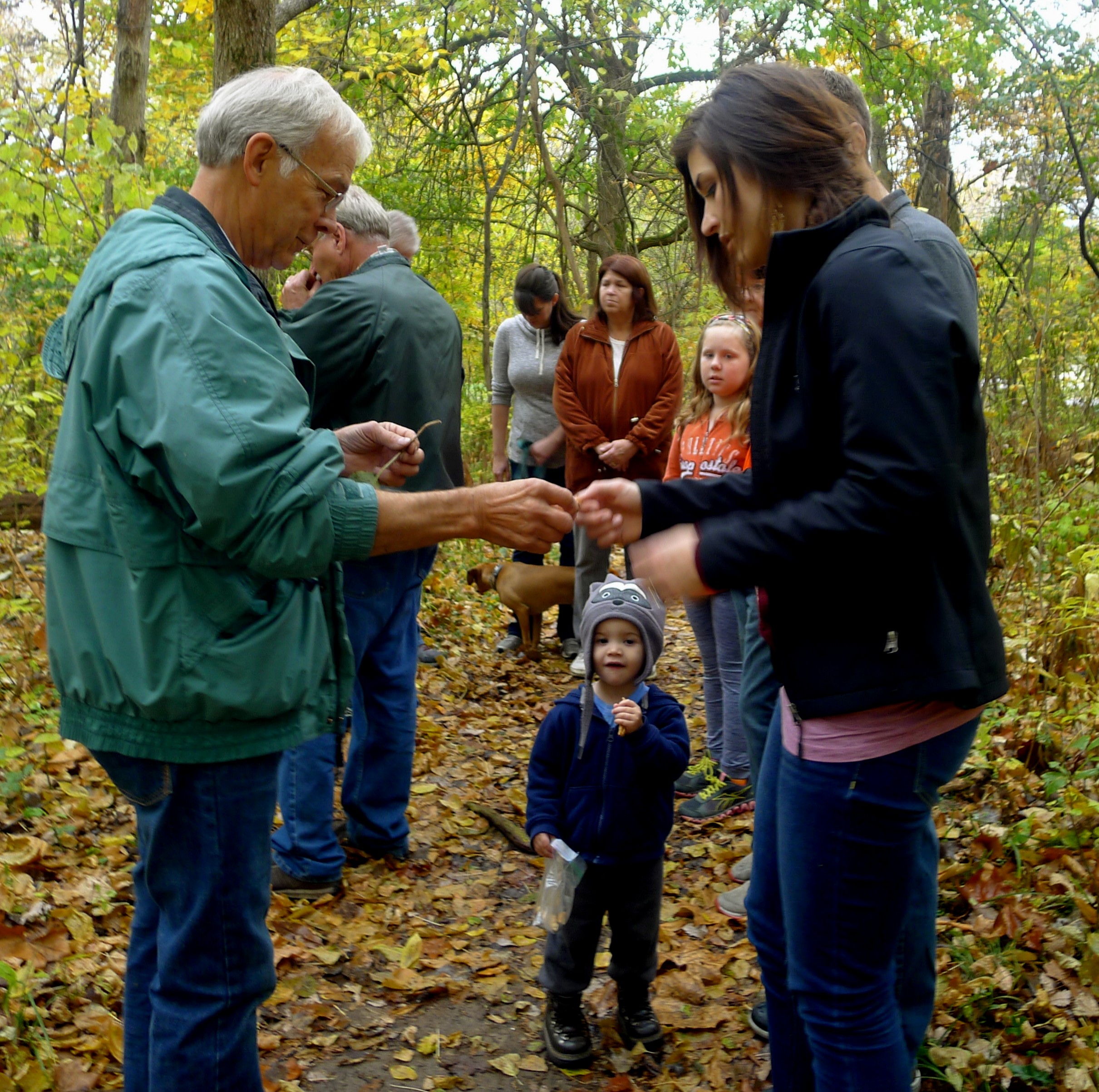 Luke Hunt, a certified naturalist in Indiana, leads the 2015 fall interpretive hike attendees through Heritage Trail in Winona Lake, noting natural features found along the trail.