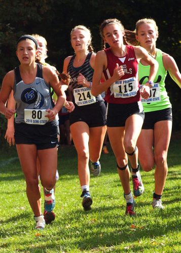 Warsaw's Mia Beckham (214) is at the center of the lead pack as runners emerge from a woods about 3,000-meters into the IHSAA girls cross country semistate race Saturday at New Prairie. Beckham eventually finished fourth. At right is semistate champ Jordyn Boyer of Lowell (115). (Photos by Tim Creason)