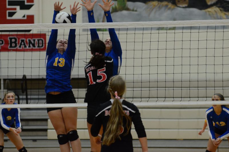 Kaitlin Bailey (No. 13) puts up a big block for the Trojans.