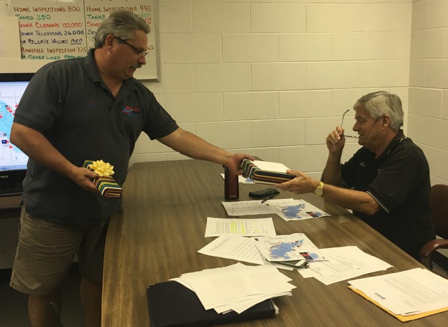 District superintendent Timothy Woodward, left, presents Joe Todd with gifts from the district.