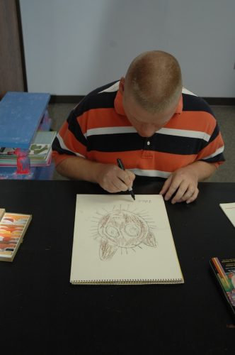 Artist signing cat drawing