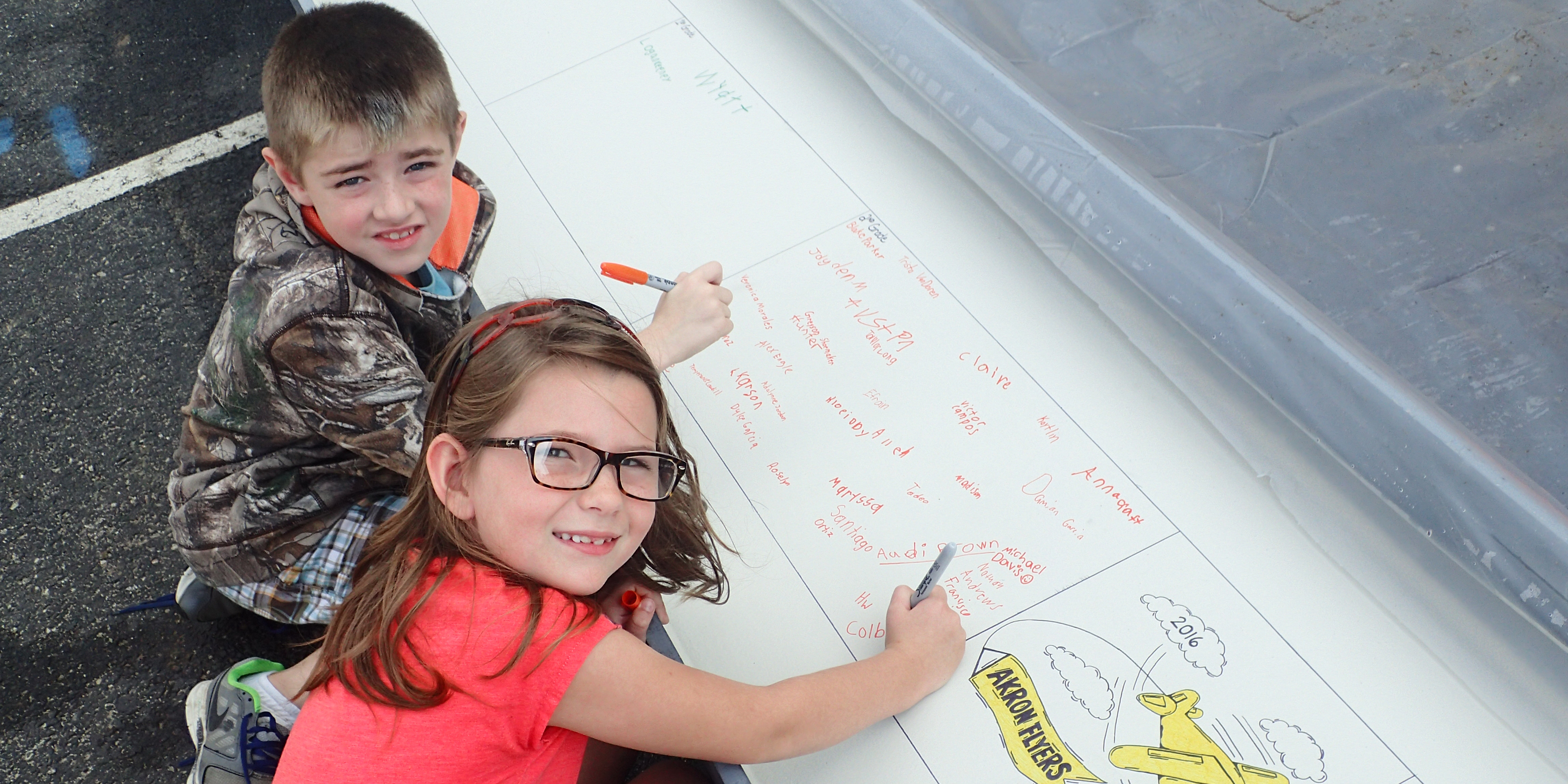 Second graders Karson Potter and Colby Seaney beam as they sign the commemorative Akron Elementary steel beam. Their signatures and those of their classmates and teachers will be seen for years after the Akron project is completed.