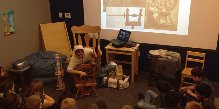 Miss Roberts teaches the kids about spinning wool.