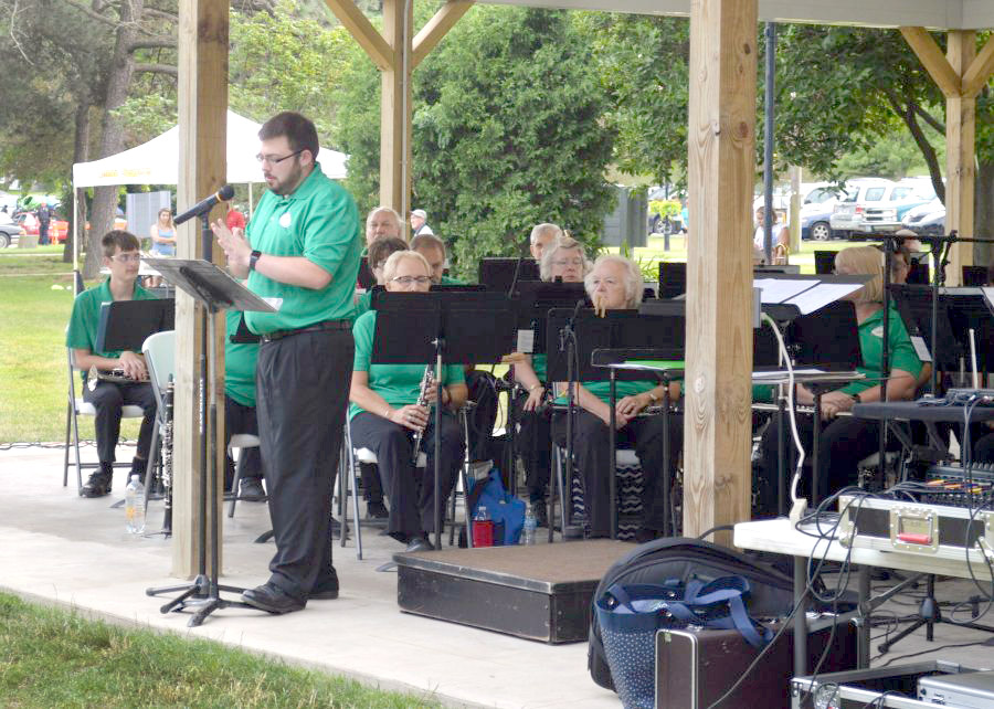 Lake Area Community Band Director Joey Shepherd addresses the crowd at the start of the concert at Lakeside Park.