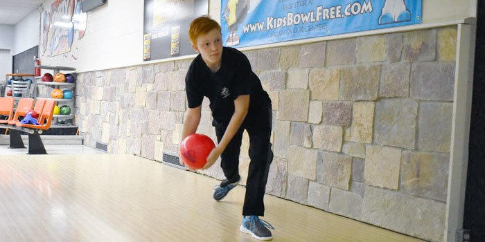 Mikey Cox bowling with a two-handed approach.