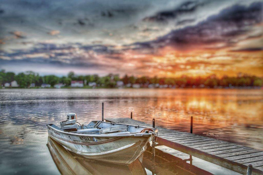 Photo of boat at dock with a beautiful orange sunrise